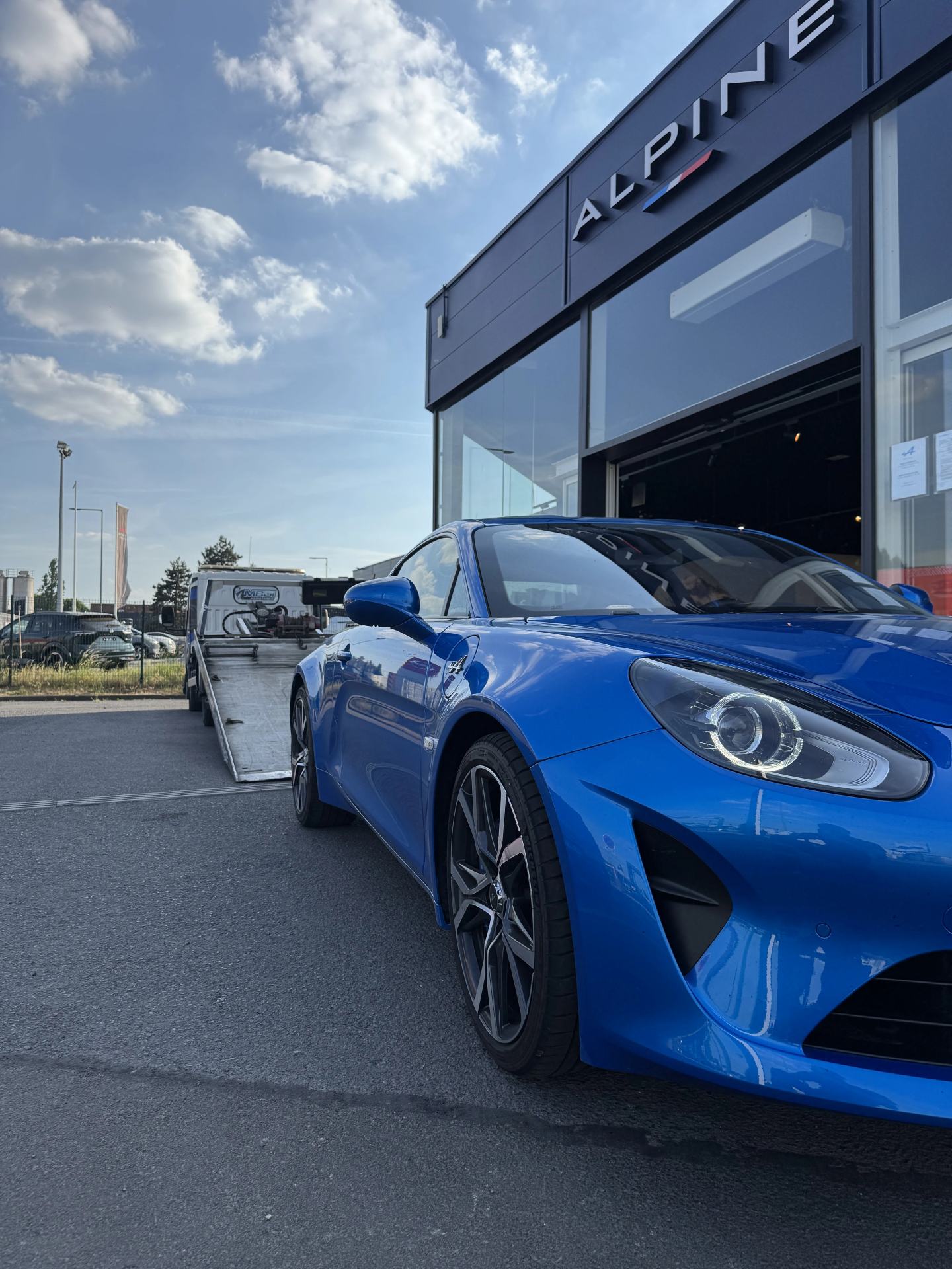 Alpine A110 bleue devant une concession